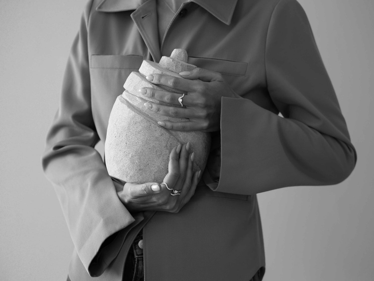 Person holding a textured vase against a plain background